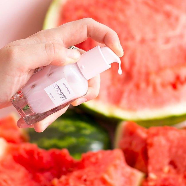a glass bottle with wave-like contours and a pink product inside