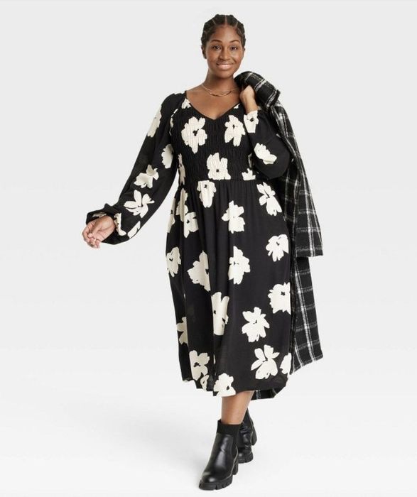 A long black dress adorned with large white flowers.
