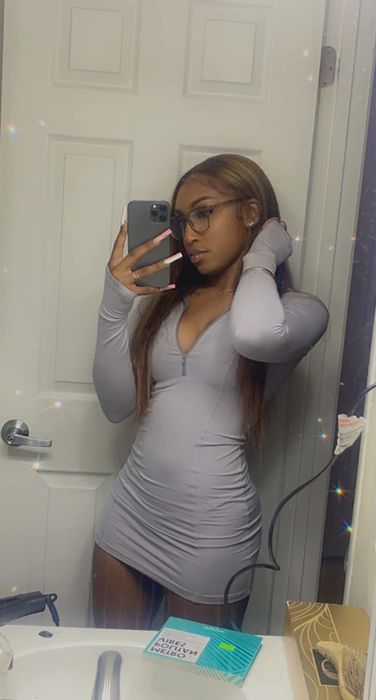 Reviewer modeling a gray long-sleeve dress with a quarter-zip neckline