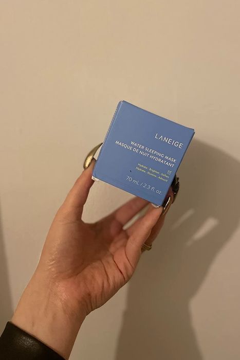 A reviewer holding a box of cream.