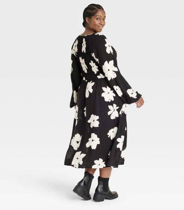 A long black dress with oversized white floral patterns.