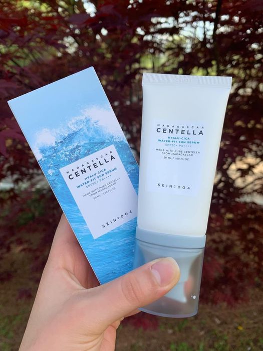 Reviewer holding the serum along with its packaging