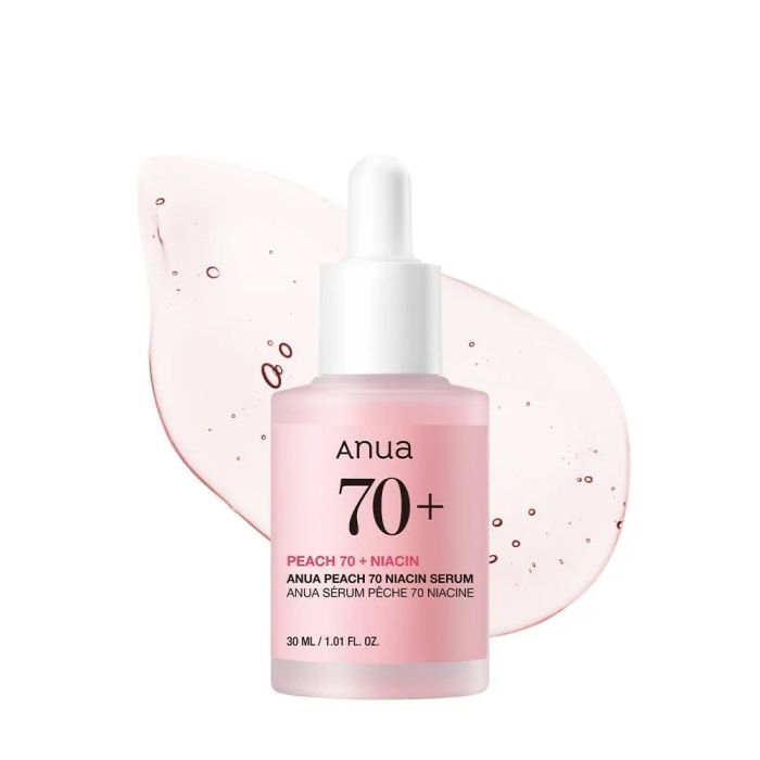 A bottle of Anua Peach 70+ Niacin Serum with a liquid drop behind it, showcasing skincare details of the product.