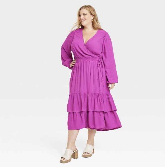 Model wearing the pink version of the dress with white open-toe heels