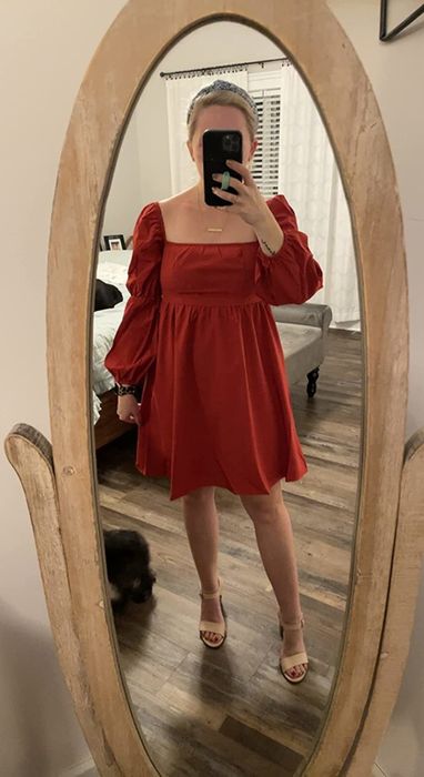 Reviewer wearing a red puff-sleeve mini dress paired with tan heels