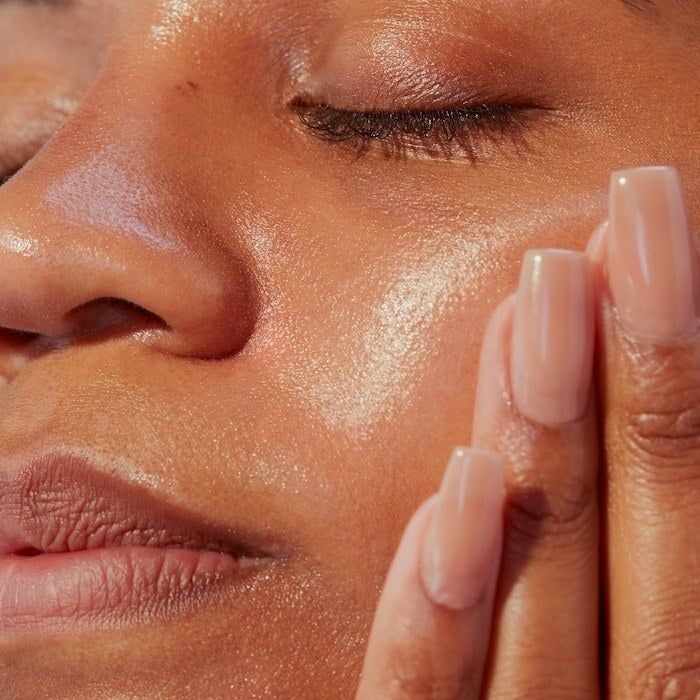 A model applying the moisturizing sunscreen to their skin.