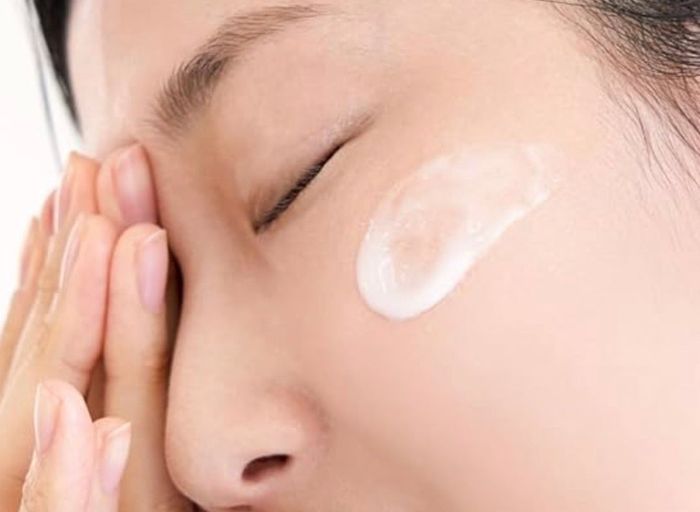 Model with a dollop of the cream applied to their skin