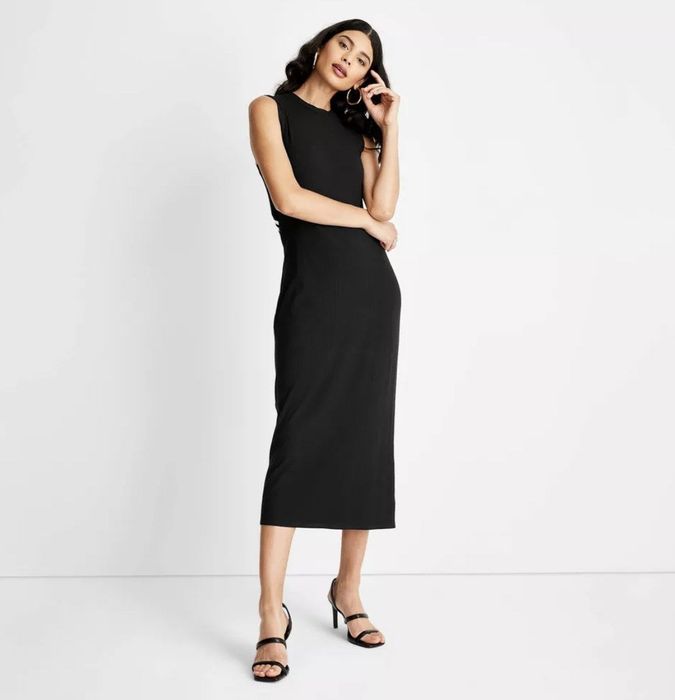 A sleek black ribbed A-line dress designed with a striking cut-out back.