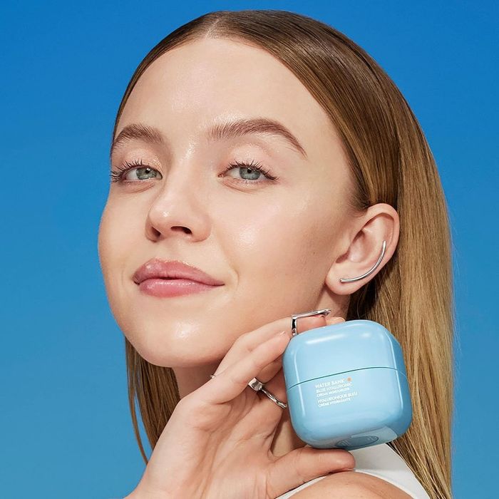 A model holding a jar of cream.