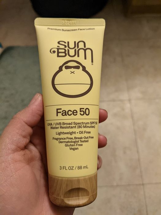 A reviewer holding the SPF moisturizer in their hand.