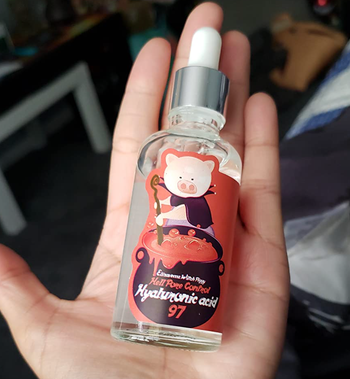 A bottle of the serum featuring a whimsical pig witch illustration