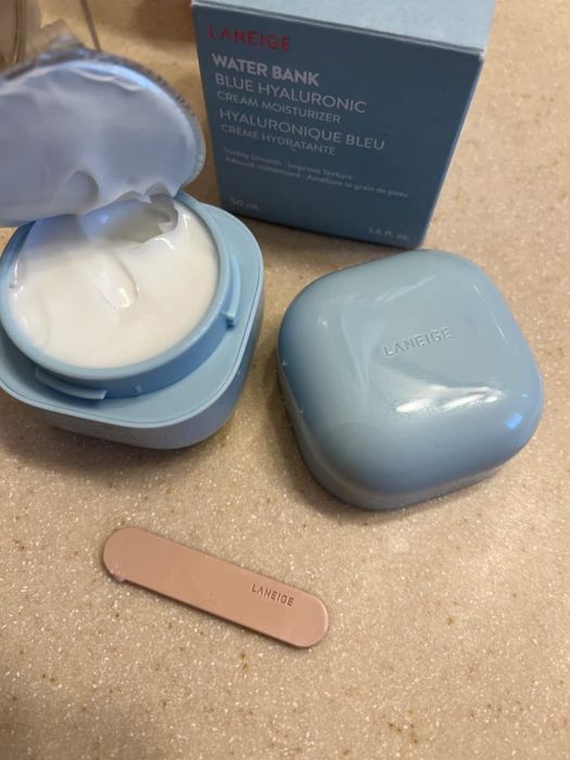 A reviewer's photo featuring the cream, box, and application stick.