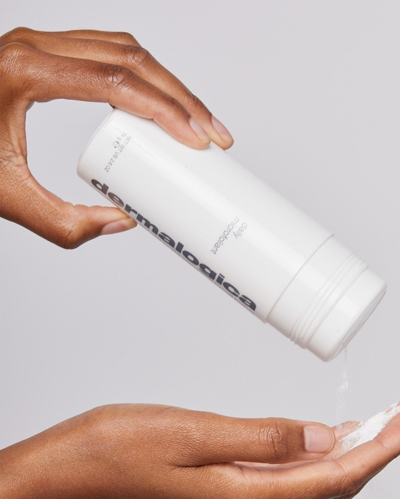 Exfoliator powder being poured onto the model's hand.