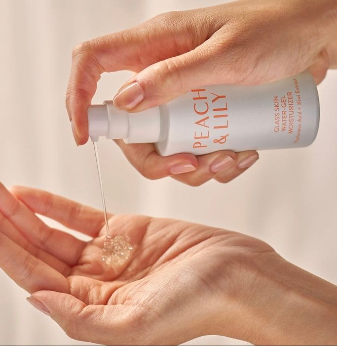 A model dispensing some of the product from the bottle onto their hand