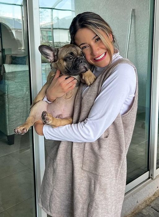 A reviewer wearing the khaki dress and holding their dog