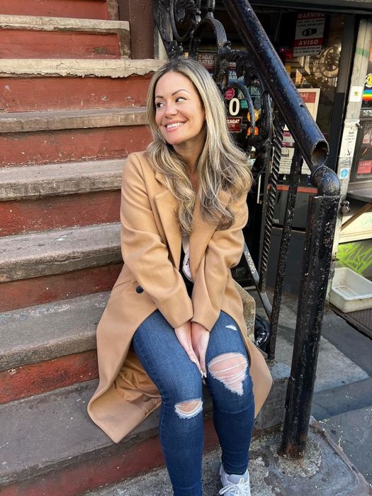 A reviewer showcasing the khaki coat