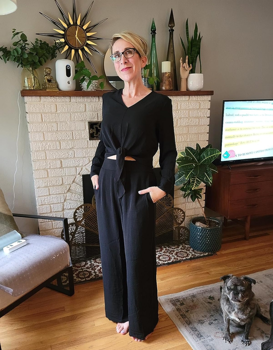 reviewer in a sophisticated black jumpsuit with a belt