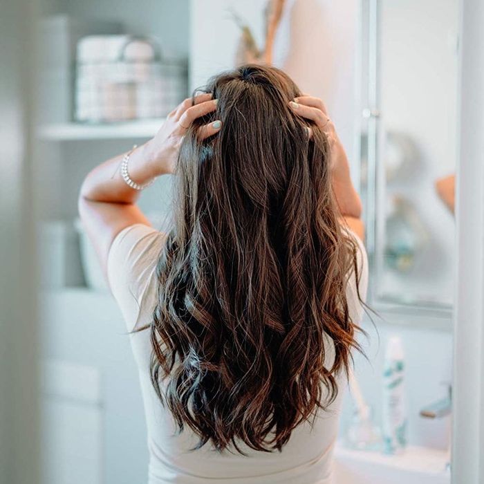 Model styling their hair after using the dry shampoo foam