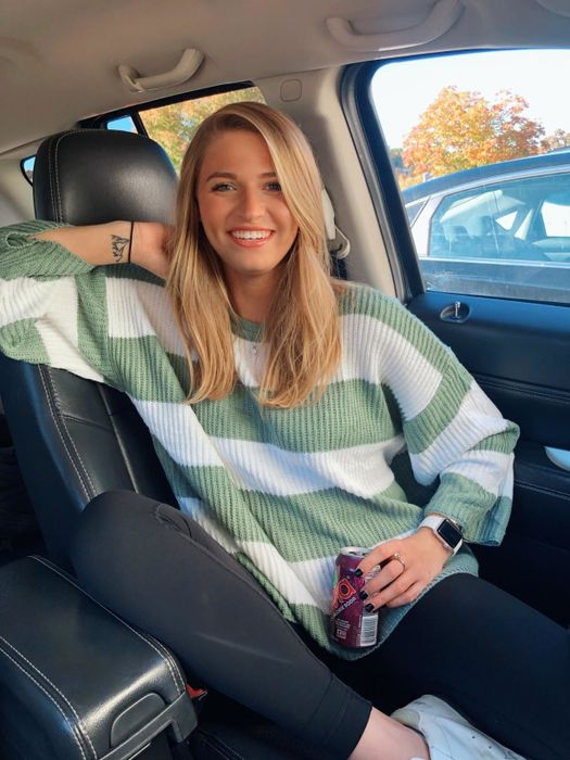 A reviewer showcasing the green sweater