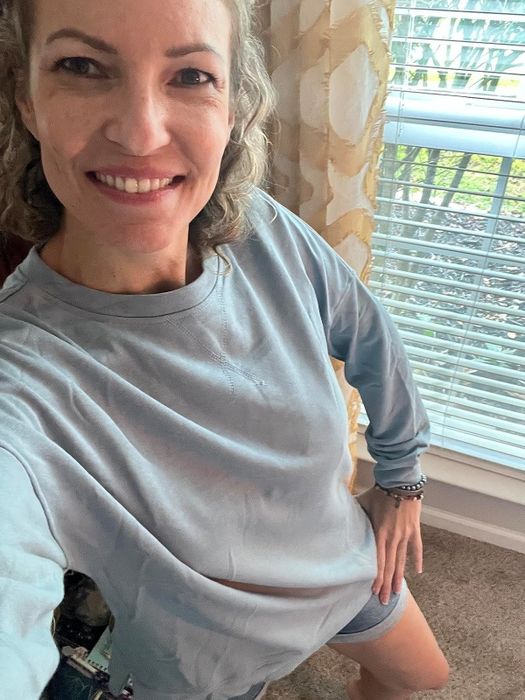 A reviewer modeling the blue crewneck