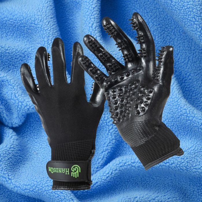 Two black grooming gloves with textured nodules for pet grooming are shown against a blue fleece fabric background.