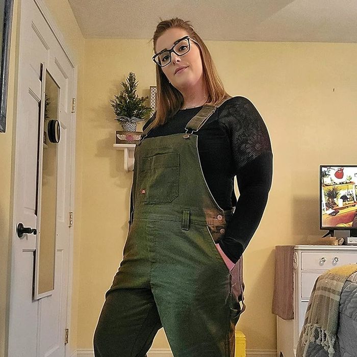 A reviewer showcasing the moss green overalls