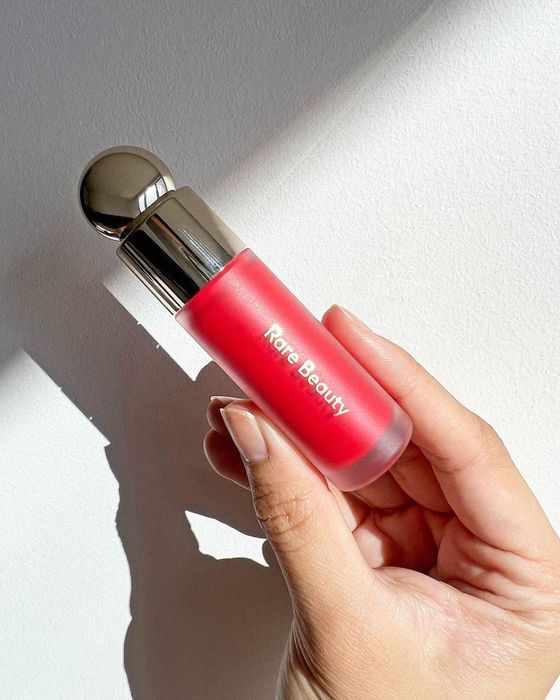 An opened tube of vibrant red liquid blush