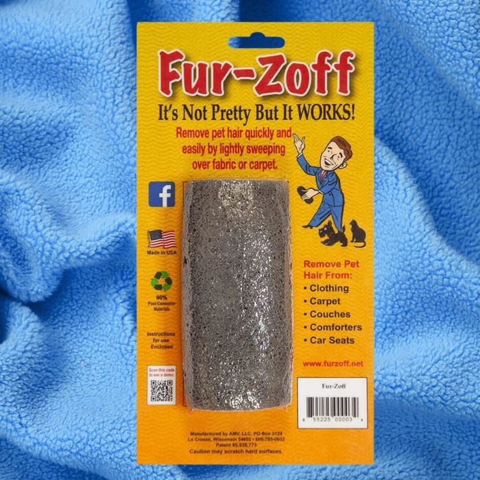 The packaging of the Fur-Zoff pet hair remover is displayed against a blue fabric backdrop. The design highlights key product details and branding, showcasing its efficiency across multiple surfaces.