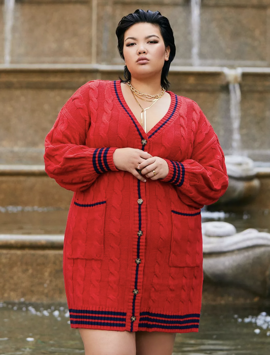 Model showcasing a red cable-knit button-down sweater dress.