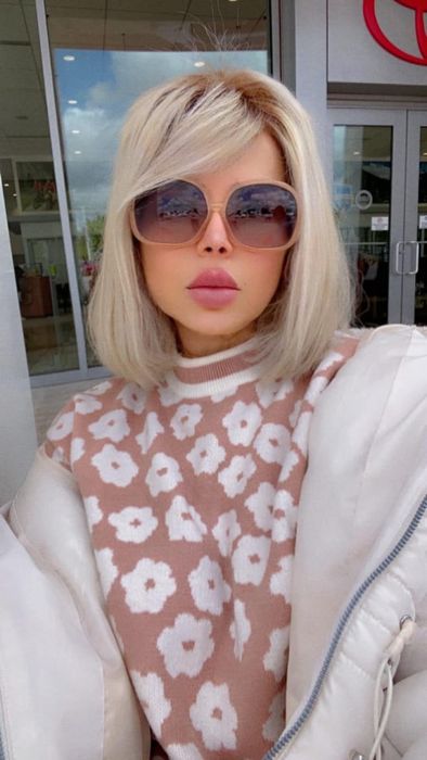 reviewer wearing a floral sweater and sunglasses