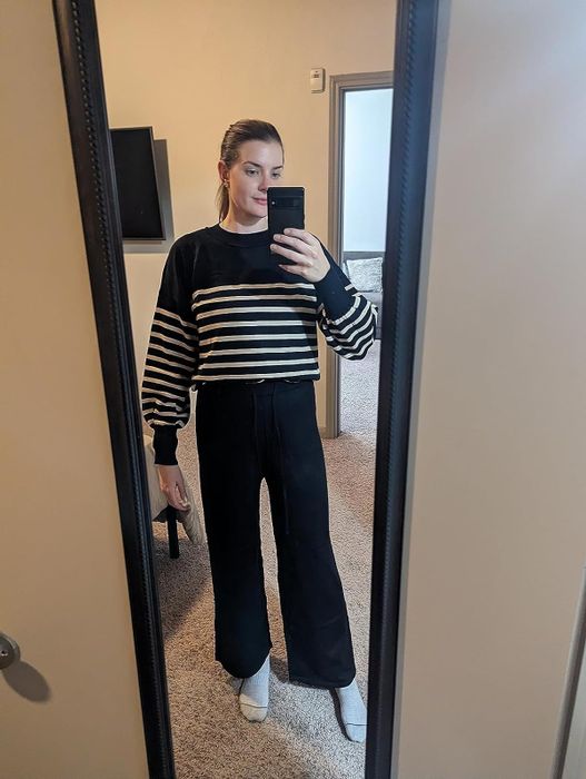 reviewer taking a mirror selfie in a striped shirt and wide-leg pants