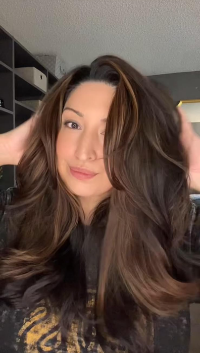 Reviewer flaunting their voluminous, layered hairstyle achieved with the brush