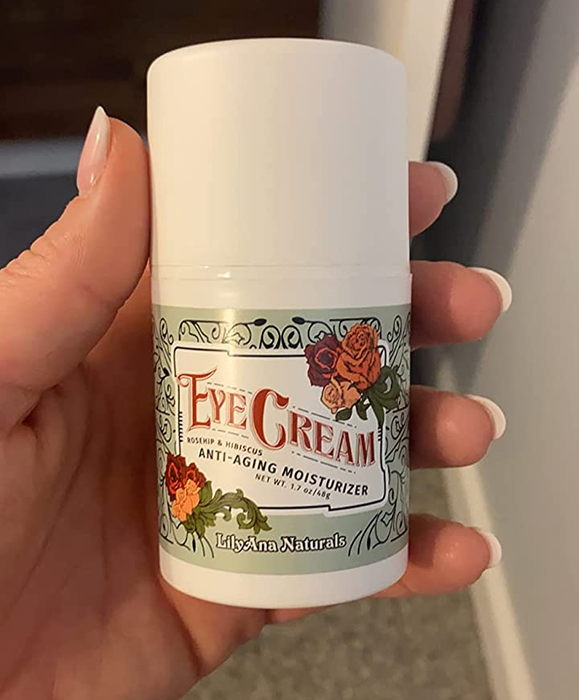 a reviewer holding the eye cream jar