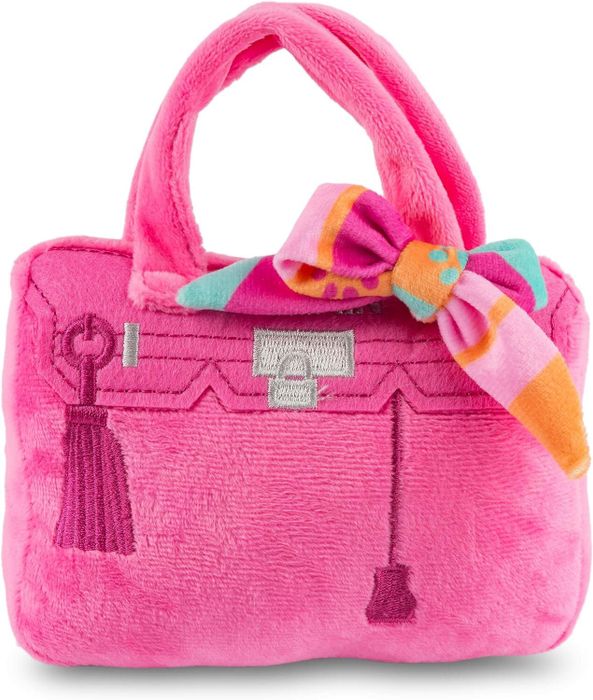 A plush pink handbag toy with embroidered details and a colorful bow around the handle.