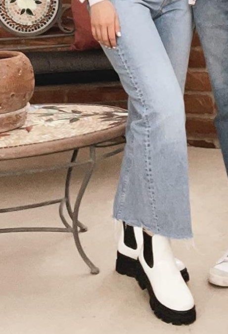 A reviewer modeling the black and white boots