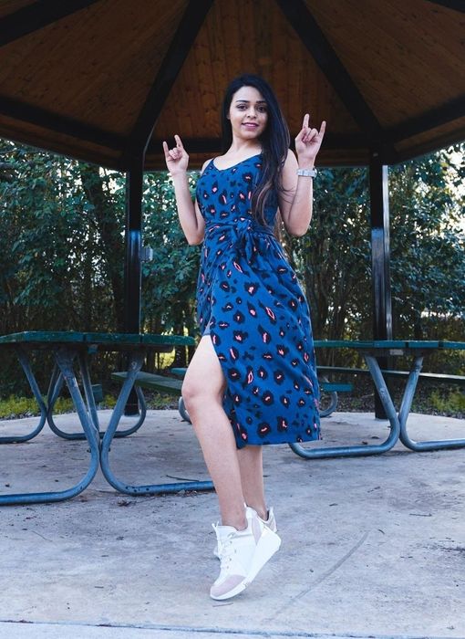Reviewer wearing the blue leopard dress paired with white sneakers.