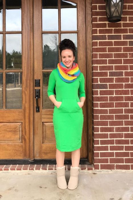 Reviewer wearing the dress in green, accessorized with a rainbow scarf.