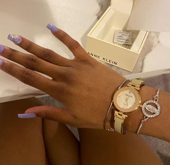 A reviewer wearing the tan and gold watch