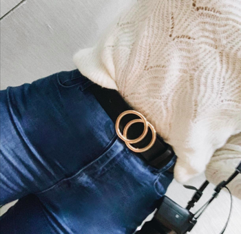 reviewer styling the faux leather belt with jeans and a sweater