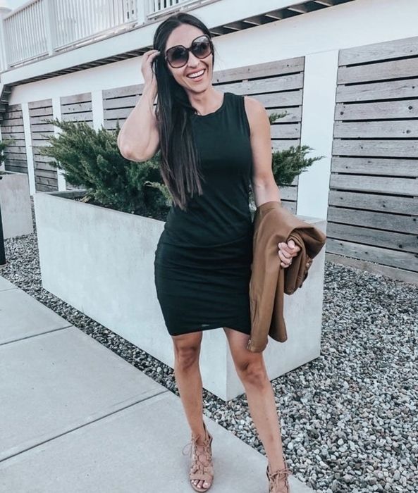 A person confidently wearing a sleek black dress.