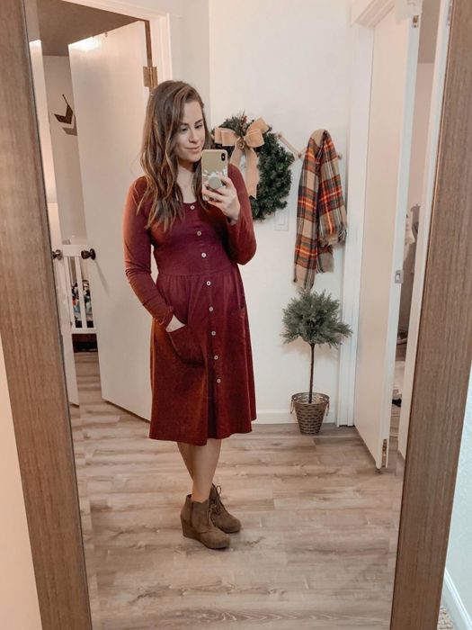 Reviewer in a burgundy dress paired with heeled booties.