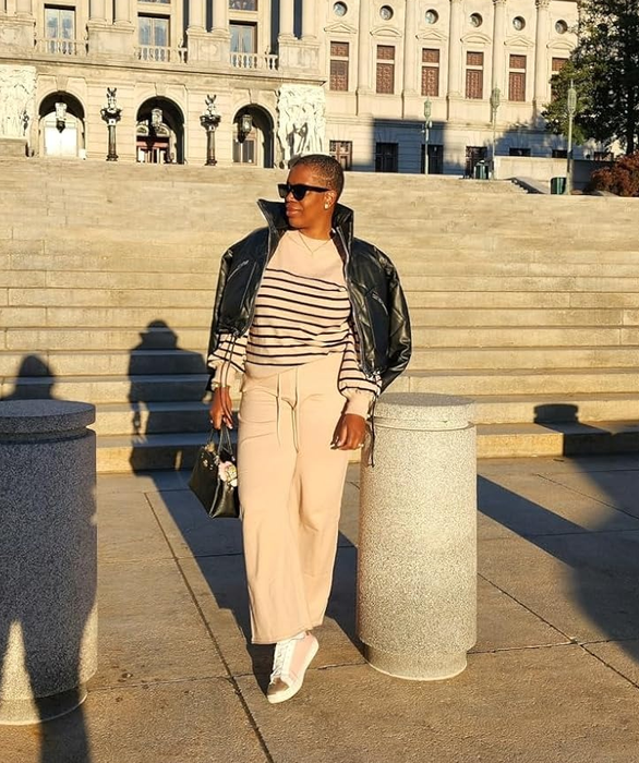 reviewer wearing a striped top, wide-leg pants, and a jacket