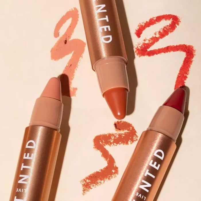 three tubes of the huestick corrector in shades of pink, nude, and red