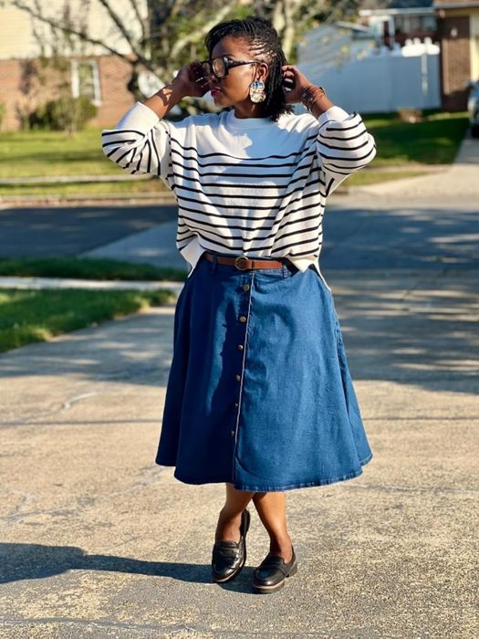 A reviewer modeling the chic striped white sweater