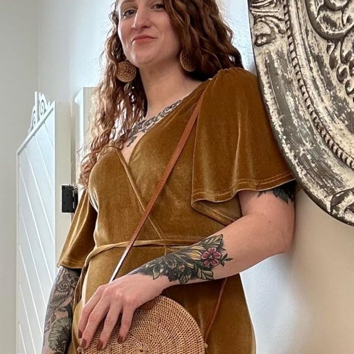 A reviewer modeling the brown handbag