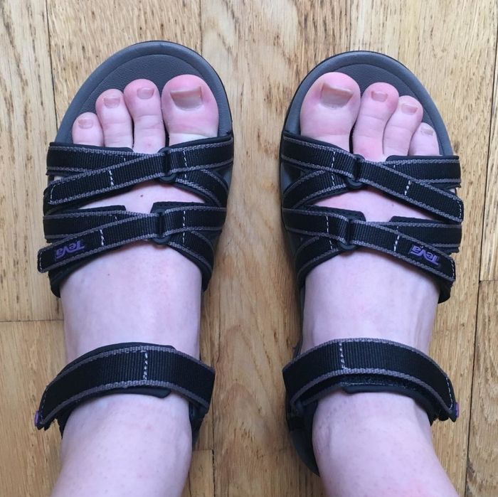 A top-down view of a reviewer wearing the black sandals