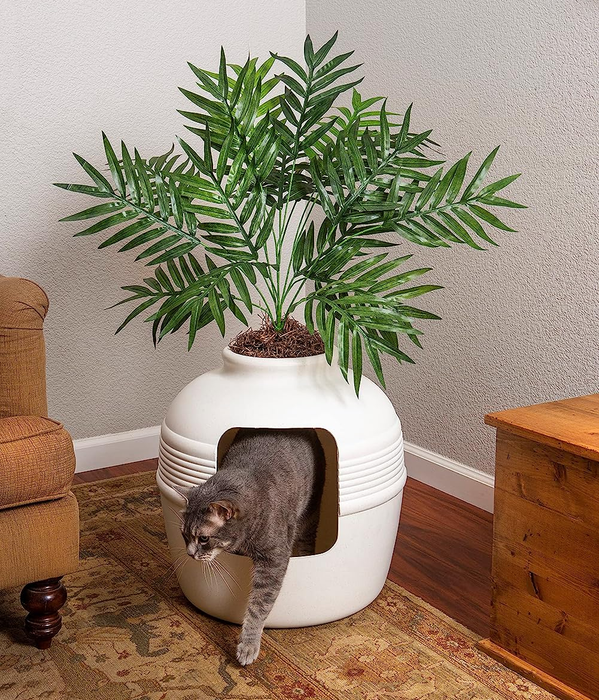 a cat emerging from the faux planter cat box
