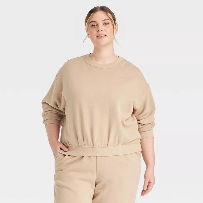 A person is dressed in a casual, oversized sweatshirt paired with matching sweatpants.