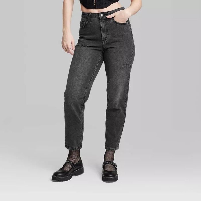A model wearing high-rise denim jeans in a faded black wash