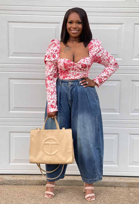 A reviewer wearing the loose denim bloomers paired with a floral cropped blouse.